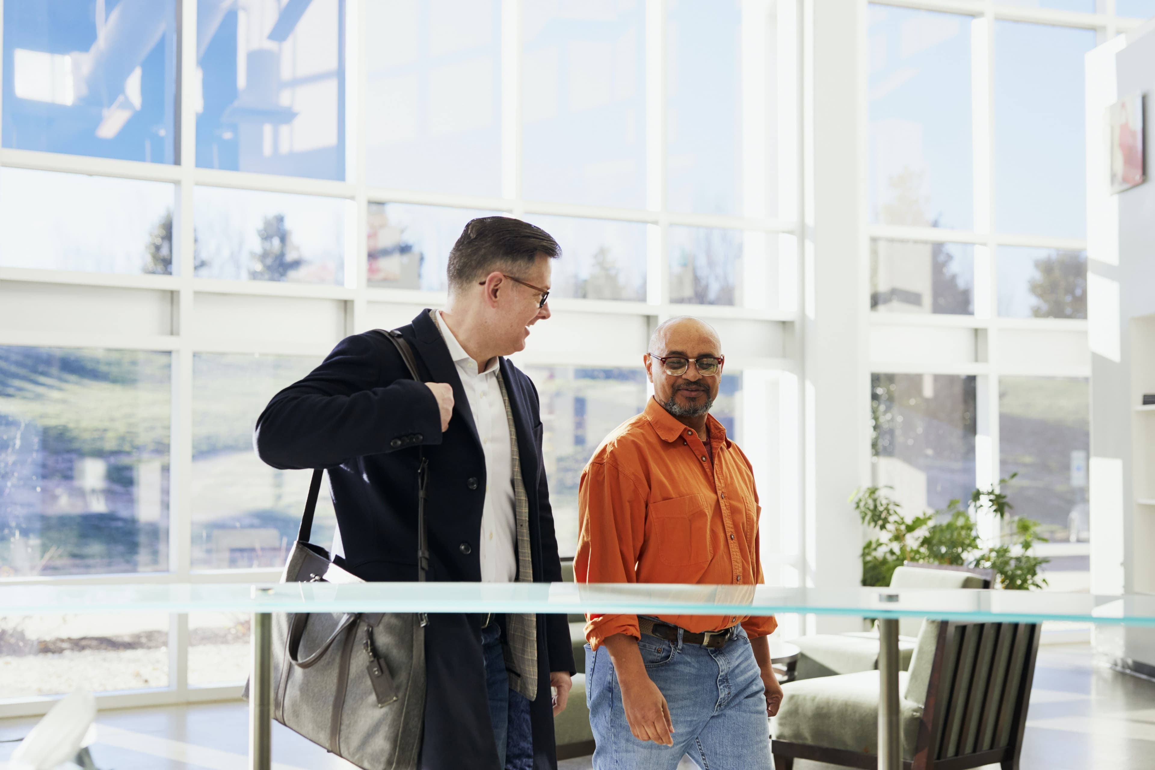two men enter a workplace building lobby