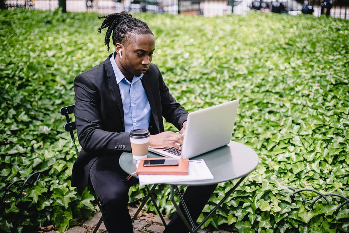 Employee focused on his laptop at an outdoor table