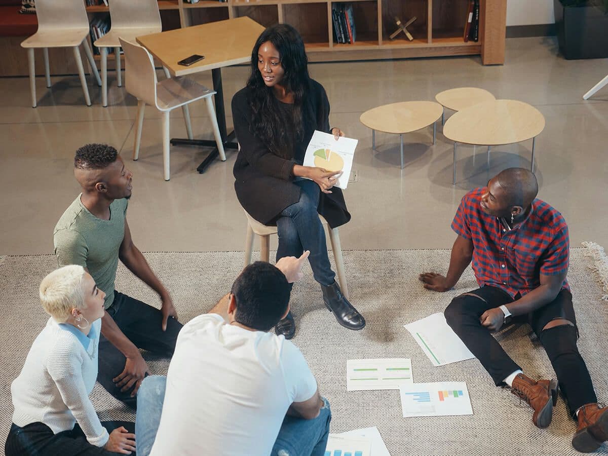 employees sitting in a circle at black employee resource group meeting on budgets and meeting schedules