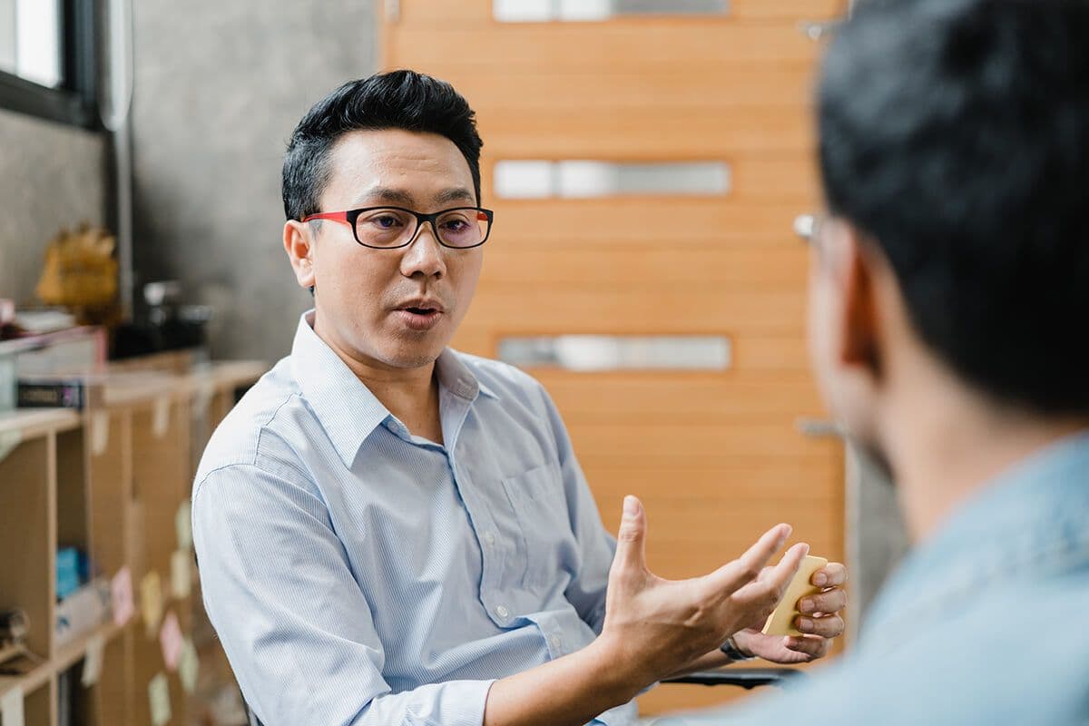 man talking to another colleague in an office about the challenges of growth mindsets in the organization